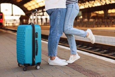 Photo of Long-distance relationship. Couple on platform of railway station, closeup