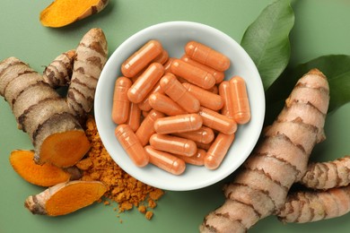 Photo of Aromatic turmeric powder, pills and raw roots on green background, flat lay