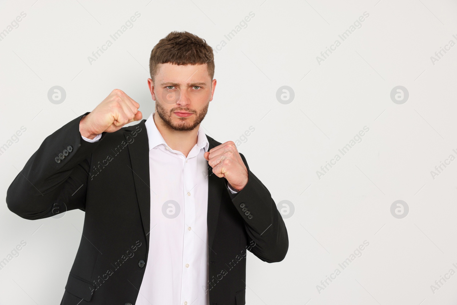 Photo of Young man ready to fight on white background, space for text