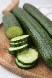 Fresh whole and cut cucumbers on table, closeup