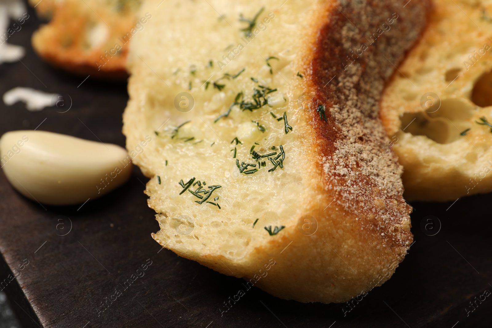 Photo of Tasty baguette with garlic and dill on table, closeup