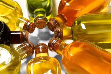 Photo of Vegetable fats. Different cooking oils in glass bottles on white background, closeup