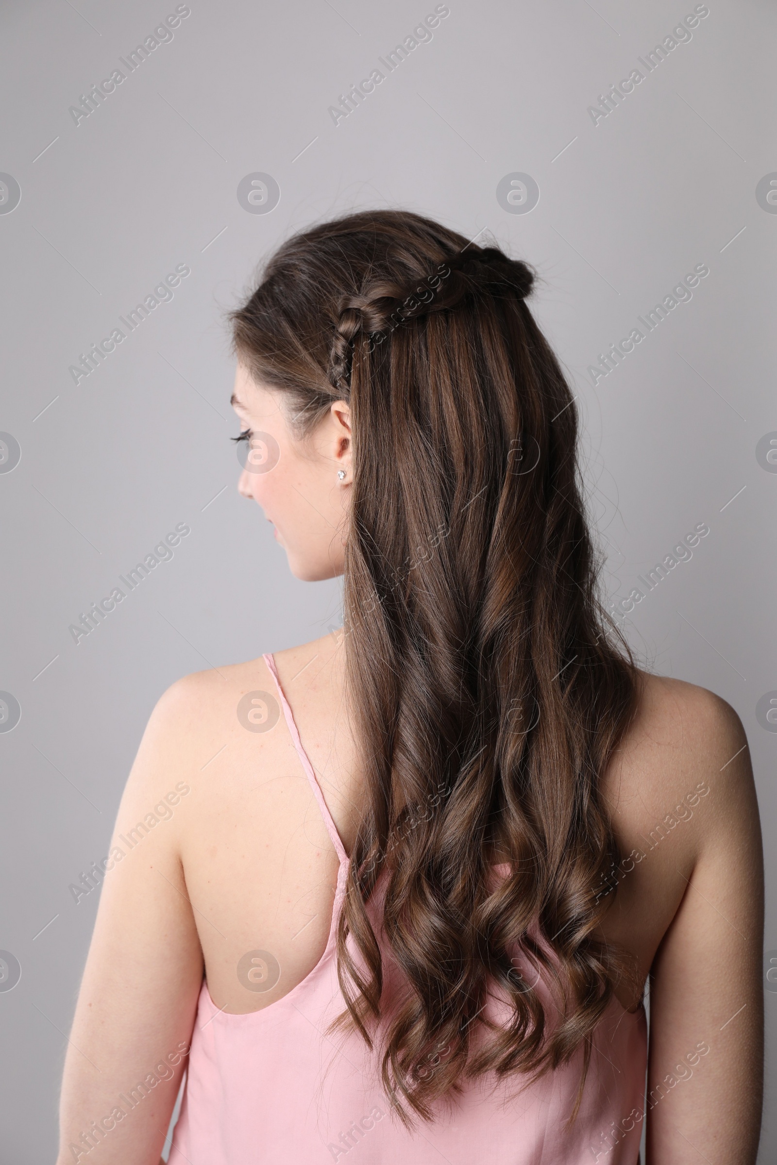 Photo of Woman with braided hair on light grey background, back view