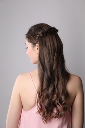 Photo of Woman with braided hair on light grey background, back view