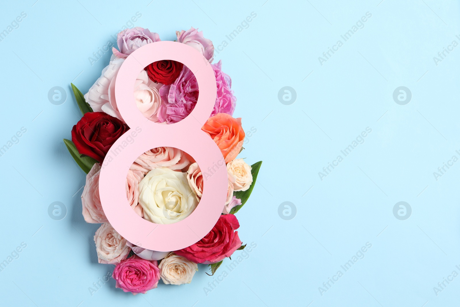 Photo of 8 March greeting card design with beautiful roses on light blue background, top view. Space for text