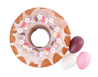 Photo of Festively decorated Easter cake and painted eggs on white background, top view