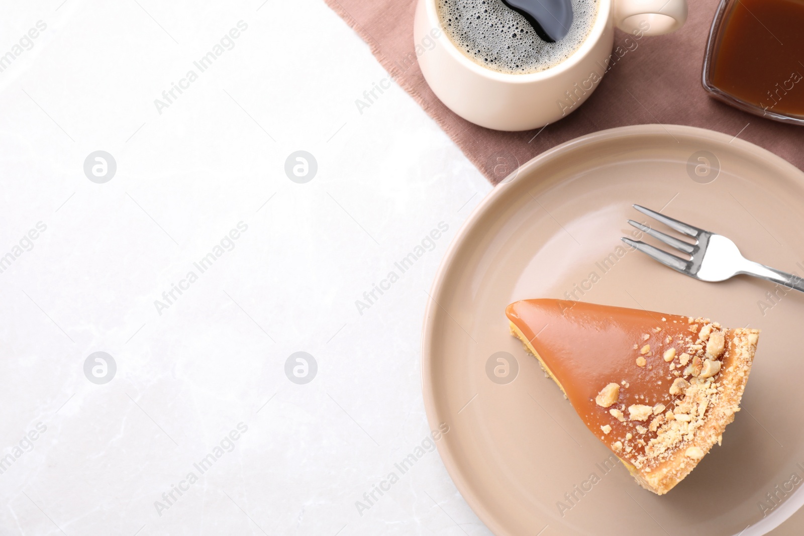 Photo of Piece of delicious cake with caramel served on light table, flat lay. Space for text