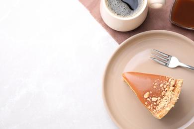 Piece of delicious cake with caramel served on light table, flat lay. Space for text