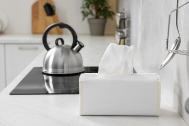 Photo of Package of paper towels on white countertop in kitchen. Space for text