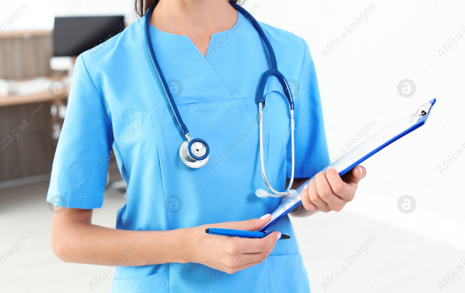 Photo of Female medical assistant with clipboard in clinic, closeup. Health care service