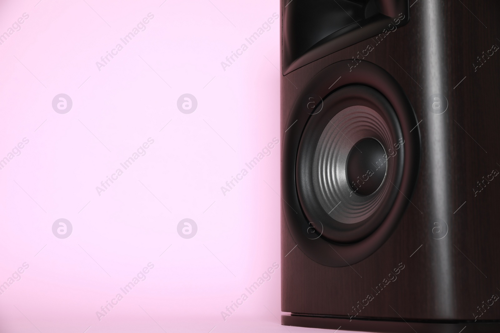 Photo of One wooden sound speaker on pink background, closeup. Space for text