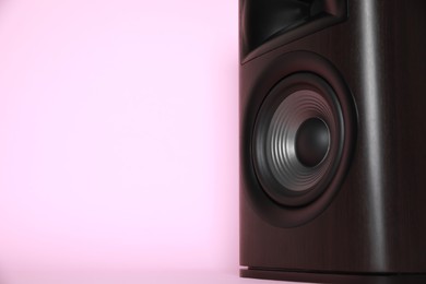 Photo of One wooden sound speaker on pink background, closeup. Space for text
