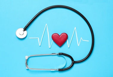 Photo of Paper cardiogram line, red heart and stethoscope on light blue background, flat lay