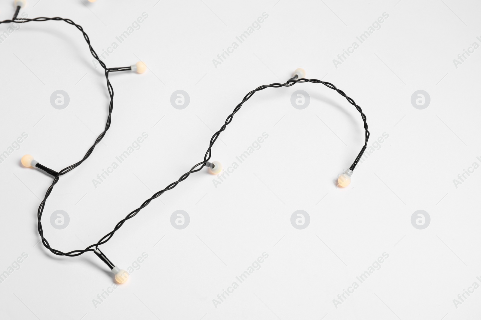 Photo of Beautiful Christmas lights on white background, top view