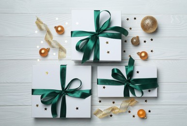 Photo of Flat lay composition with beautiful gift boxes and different Christmas decor on white wooden table
