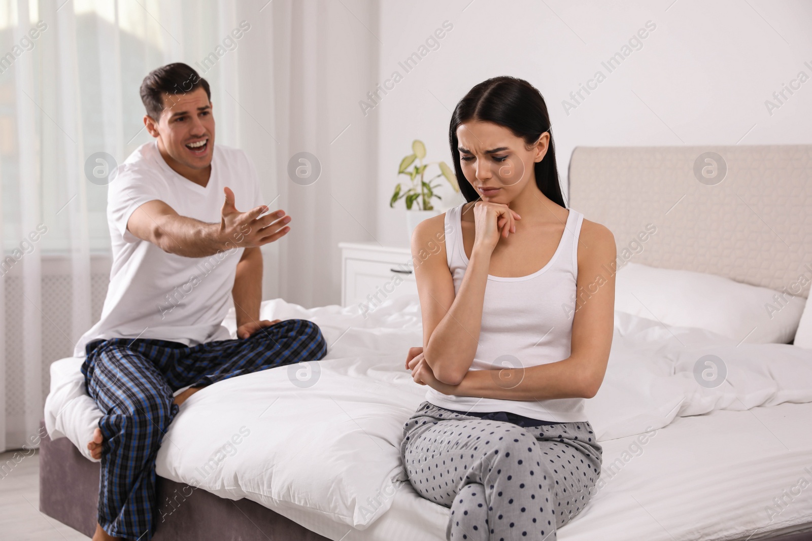 Photo of Couple with relationship problems quarreling in bedroom