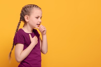 Photo of Girl coughing on orange background, space for text. Sore throat