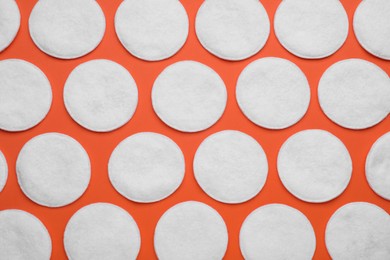 Photo of Many clean cotton pads on orange background, flat lay