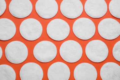 Many clean cotton pads on orange background, flat lay