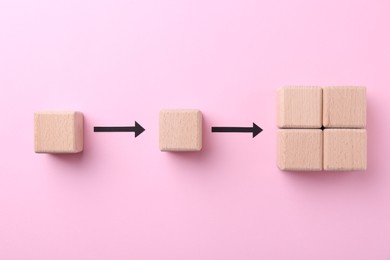 Photo of Business process organization and optimization. Scheme with wooden figures and arrows on pink background, top view