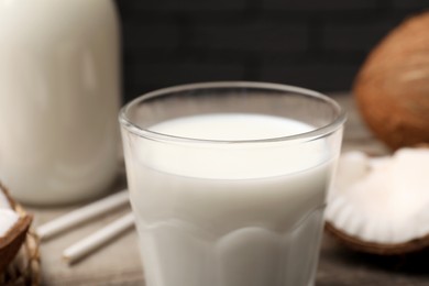 Glass of fresh coconut milk on table, closeup