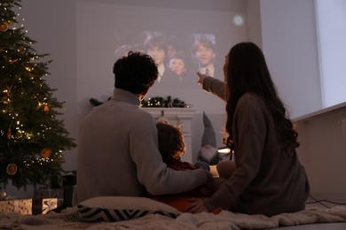 Lviv, Ukraine – January 24, 2023: Family watching Harry Potter And The Philosopher’s Stone movie via video projector at home, back view