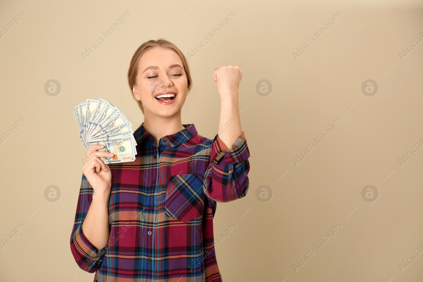 Photo of Portrait of happy young woman with money on color background. Space for text