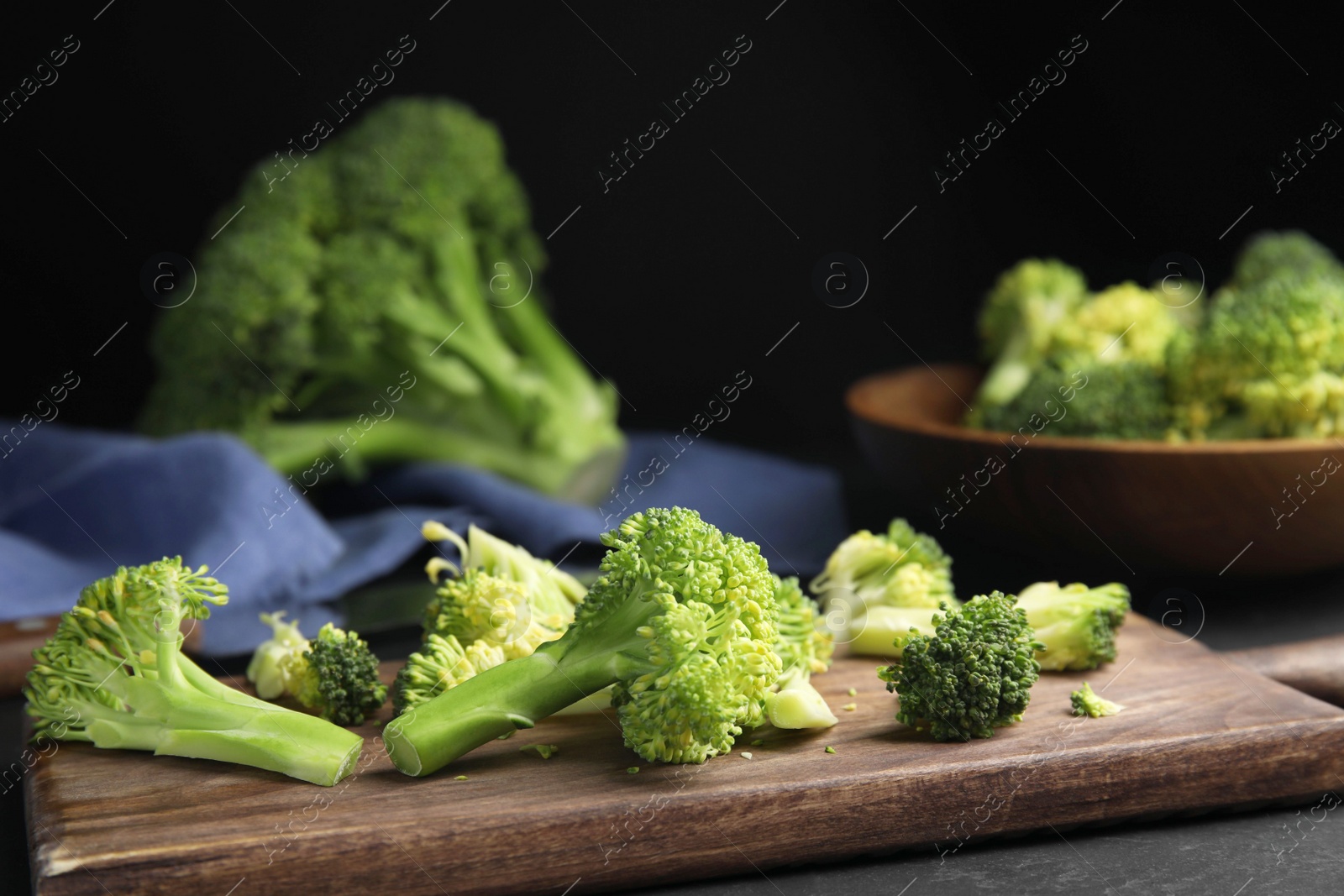 Photo of Raw green broccoli on wooden cutting board