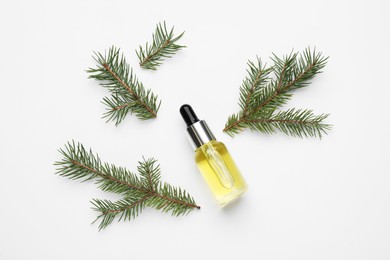 Glass bottle with essential oil and fir branches on white background, top view