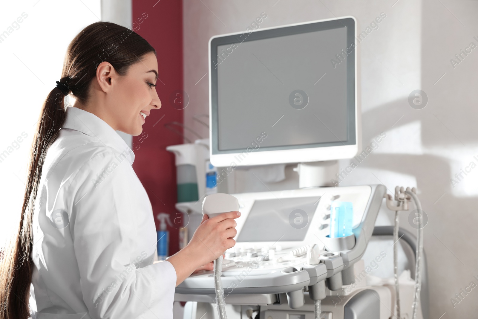 Photo of Sonographer using modern ultrasound machine in clinic