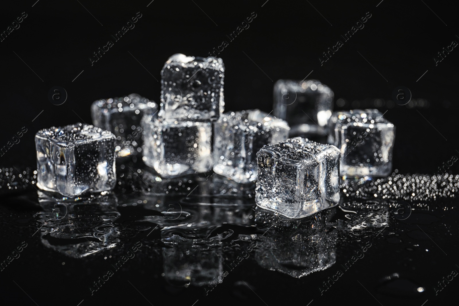 Photo of Pile of crystal clear ice cubes on black background