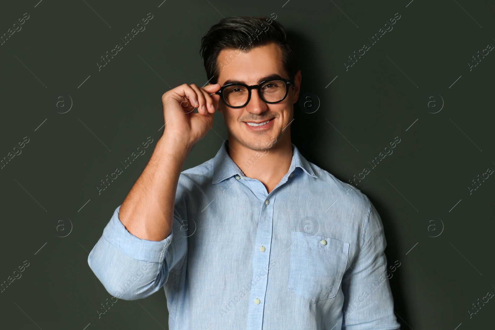 Photo of Handsome young man in stylish clothes with glasses on dark background