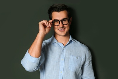 Photo of Handsome young man in stylish clothes with glasses on dark background