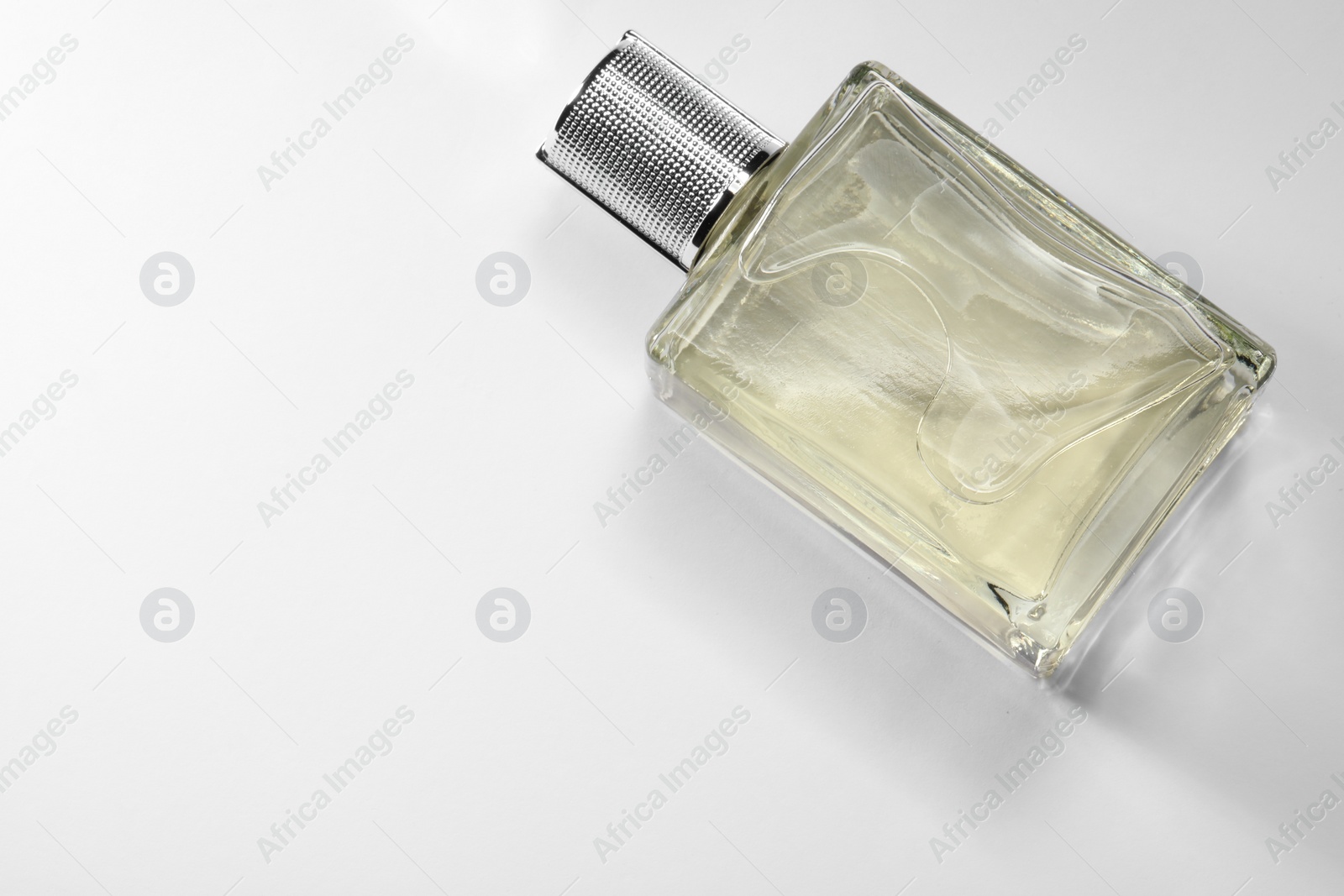 Photo of Luxury men`s perfume in bottle on white background, top view. Space for text