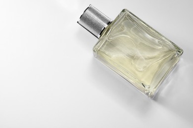 Luxury men`s perfume in bottle on white background, top view. Space for text