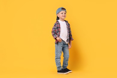 Photo of Happy little boy dancing on yellow background