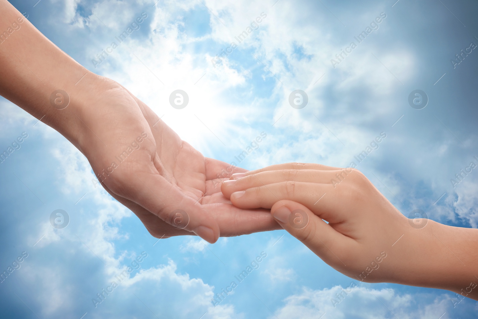 Image of Godparent with child and beautiful blue sky with fluffy clouds on background, closeup