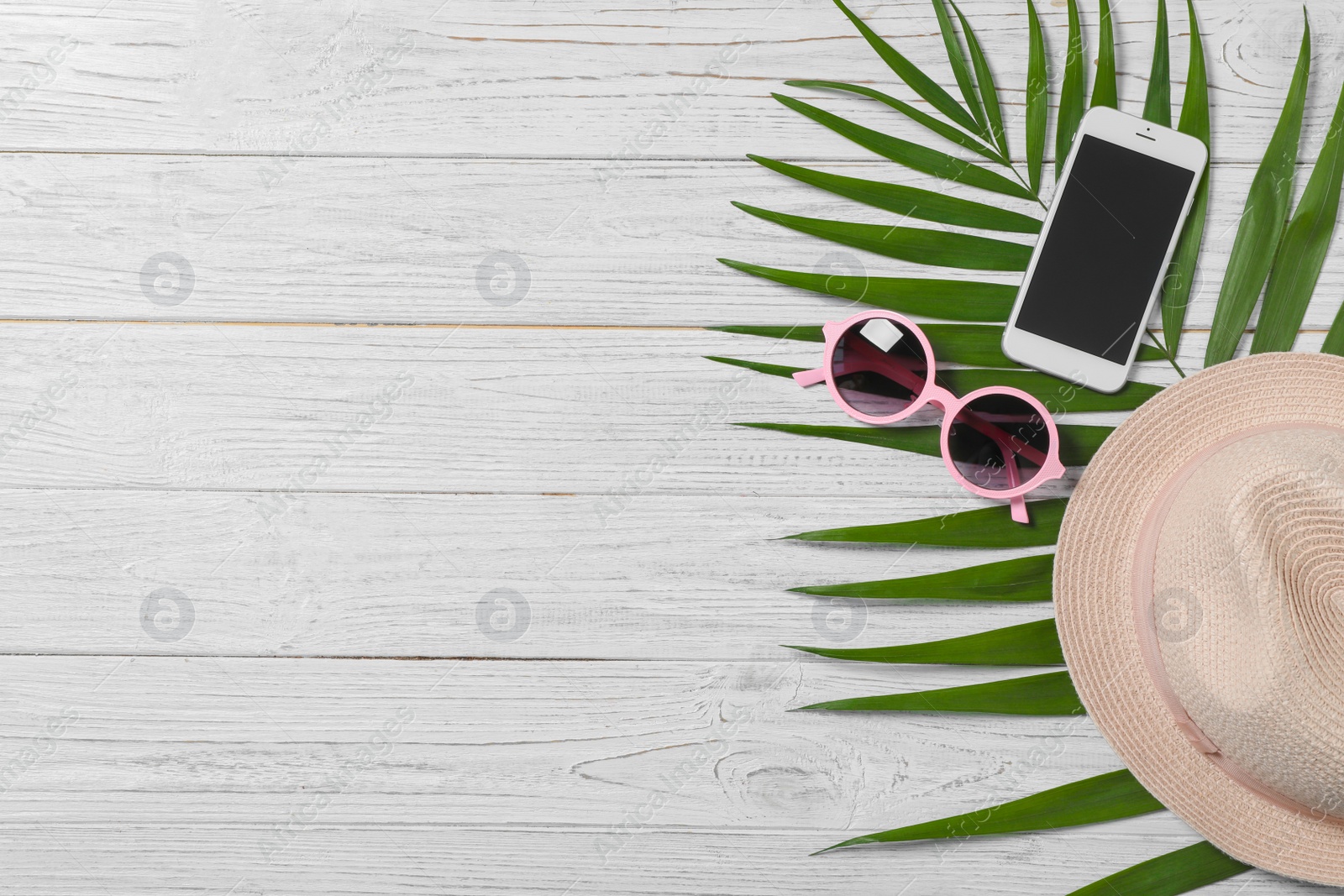 Photo of Flat lay composition with beach objects and mobile phone on wooden background