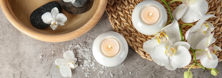 Image of Spa treatment. Flat lay composition with stones and candles on gray table. Banner design