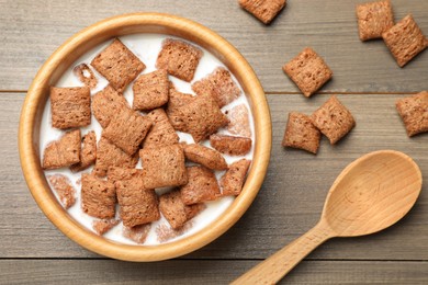 Bowl with tasty corn pads and milk on wooden table, flat lay