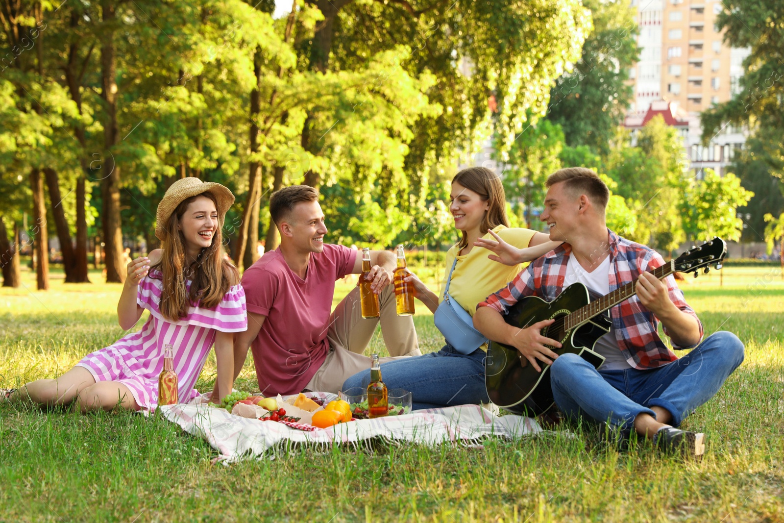 Photo of Young people enjoying picnic in park on summer day