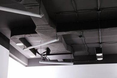 Black ceiling with lighting in office room