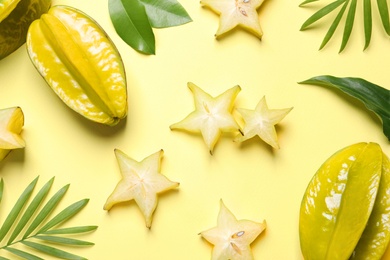 Photo of Delicious carambola fruits on yellow background, flat lay