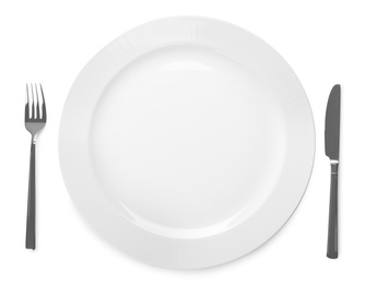 Plate and cutlery on white background, top view