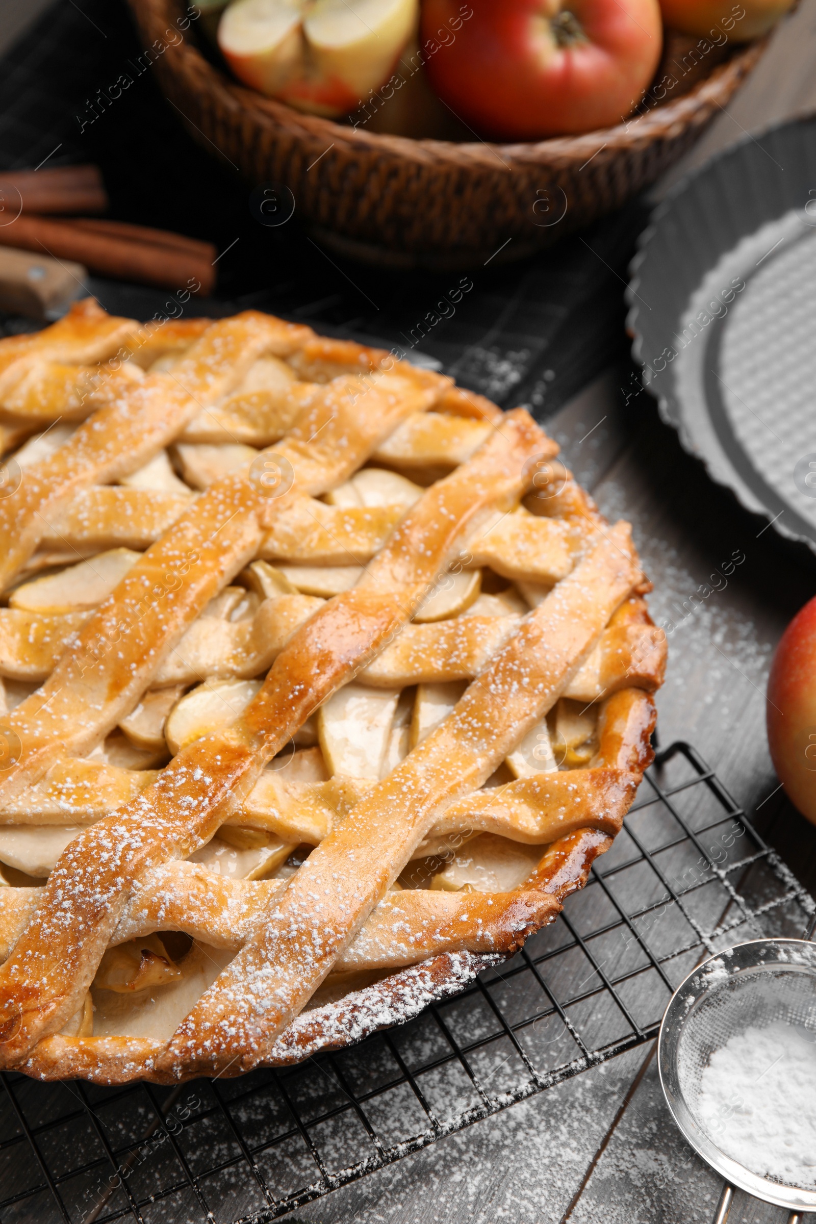 Photo of Delicious traditional apple pie with powdered sugar on table