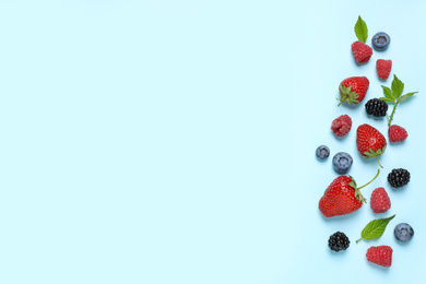 Photo of Different fresh berries on light blue background, flat lay. Space for text