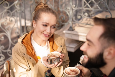 Lovely young couple enjoying tasty coffee outdoors