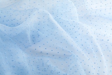 Photo of Beautiful light blue tulle fabric as background, closeup