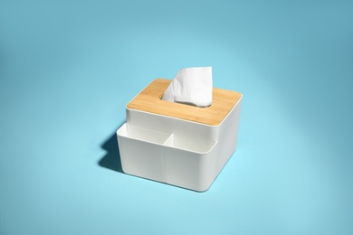 Holder with paper tissues on light blue background