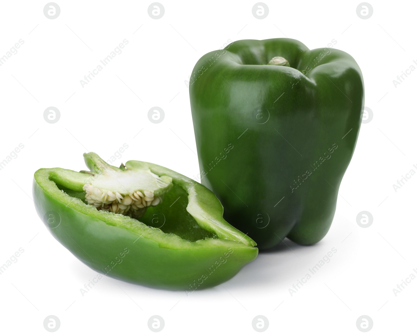 Photo of Whole and cut green bell peppers isolated on white